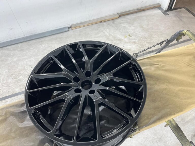 Glanzende zwarte velg op werkbank in garage.