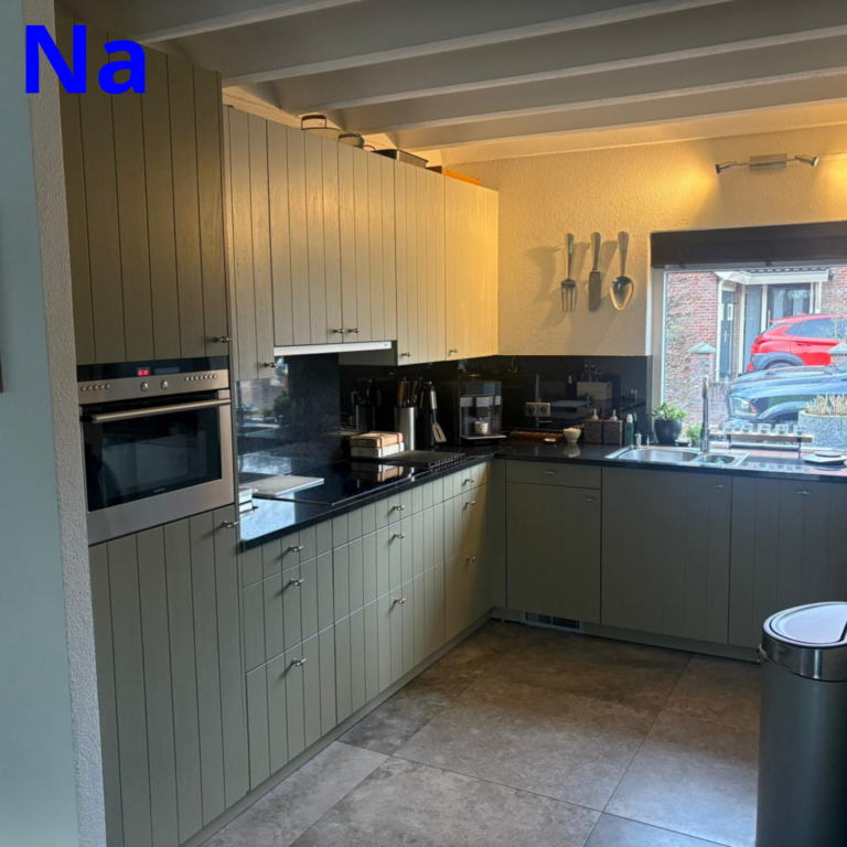 Moderne keuken met witte kasten en apparaten.