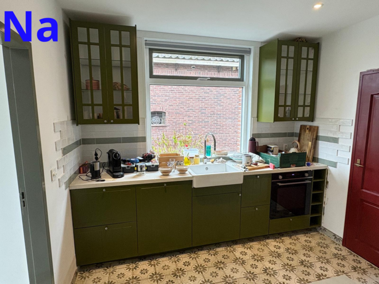 Rustieke keuken met groene kasten en tegelvloer.