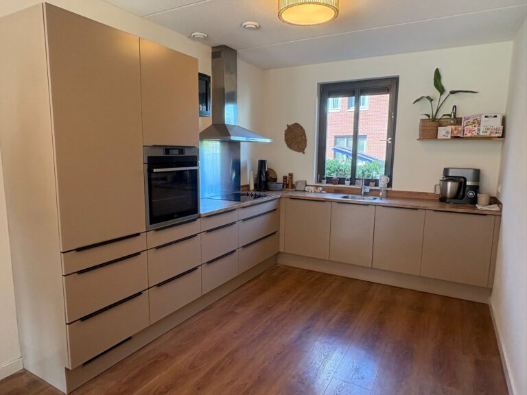 Moderne keuken met houten vloer en inbouwapparatuur.