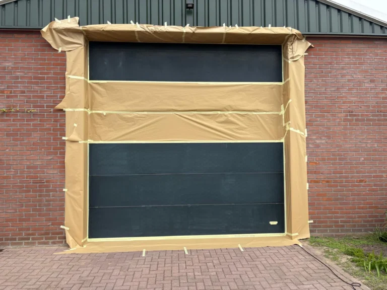 Garagepoort afgedekt met bruine beschermfolie.