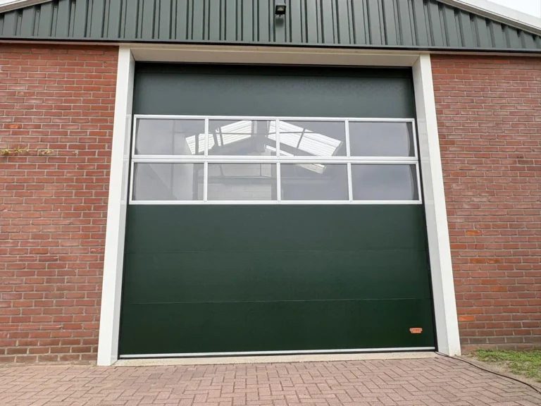 Groene sectionaaldeur van een bakstenen garage