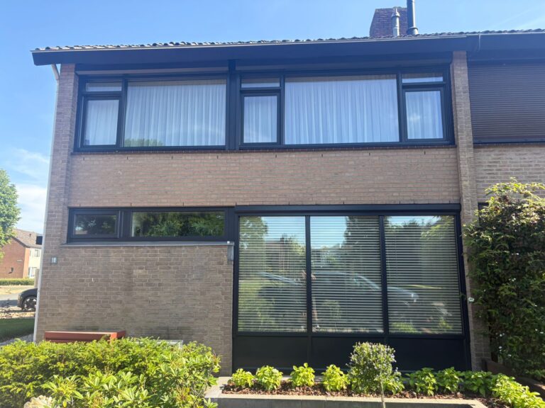 Professioneel gespoten kunststof kozijnen bij een woning in Zevenaar met een moderne zwarte afwerking.