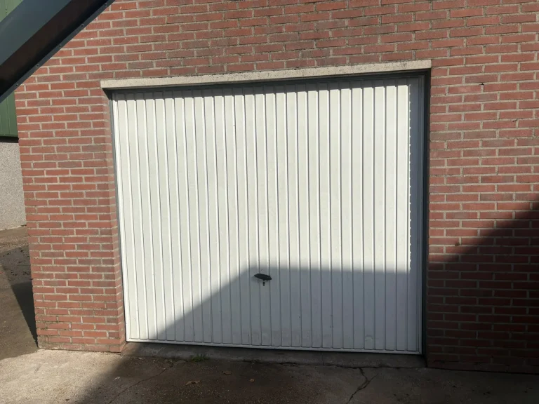 Witte kanteldeur van een bijgebouw in Winterswijk voor het spuiten door Spuit- & Wraptechniek
