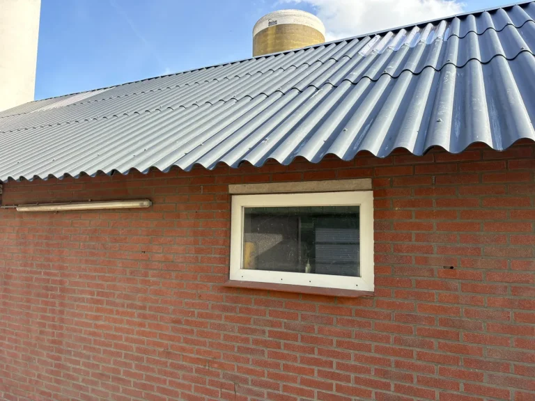 Wit kunststof kozijn in bakstenen gevel van een bijgebouw in Winterswijk voor het spuiten
